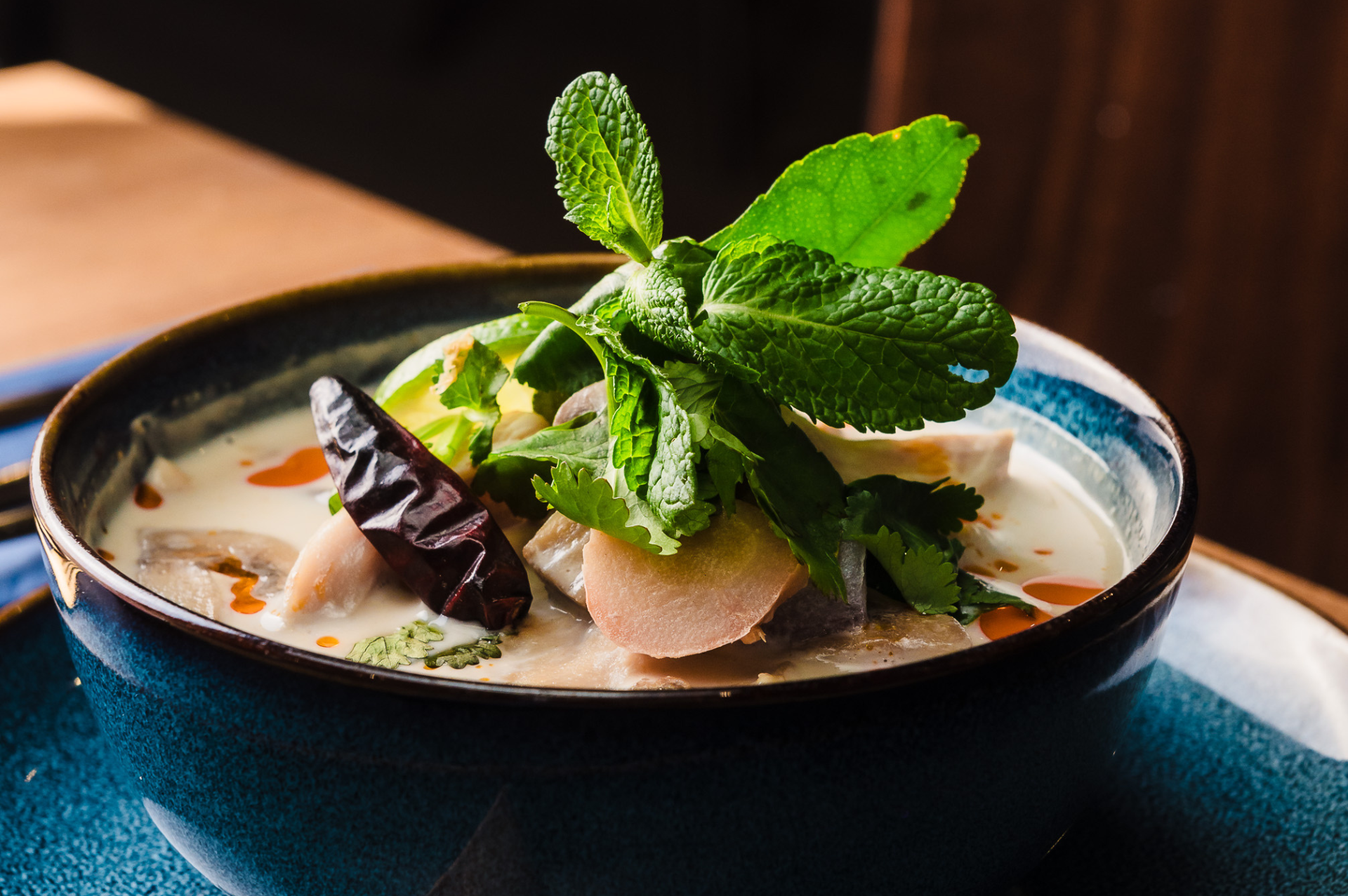 a tom kha soup with a mint garnish